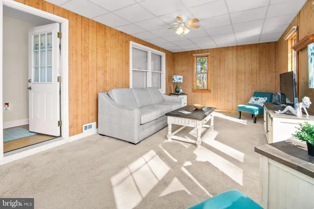 a dining room with furniture a potted plant and wooden floor