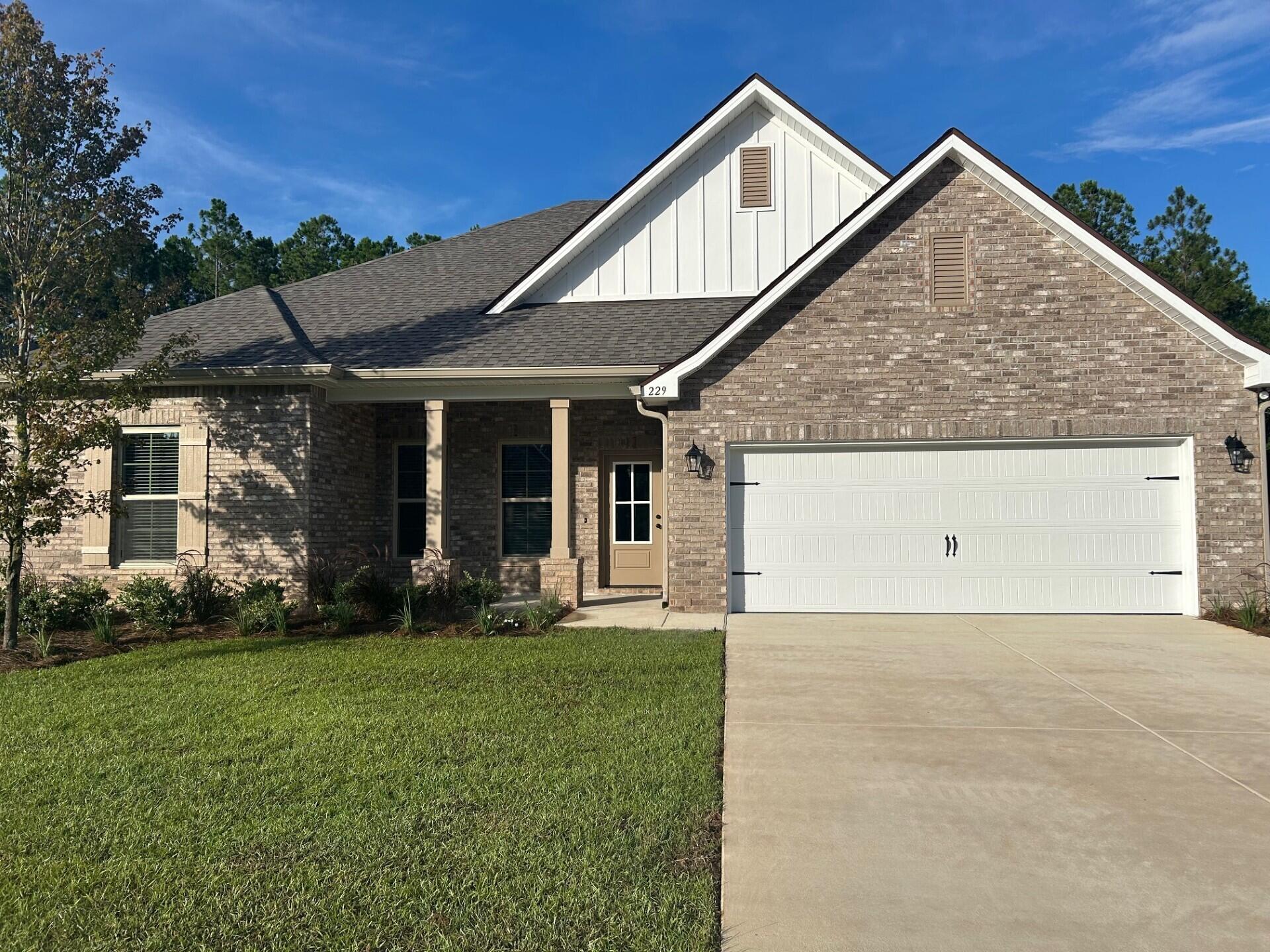229 Constellation Avenue Freeport, FL 32439 - Photo 1 of 3 a front view of a house with garden