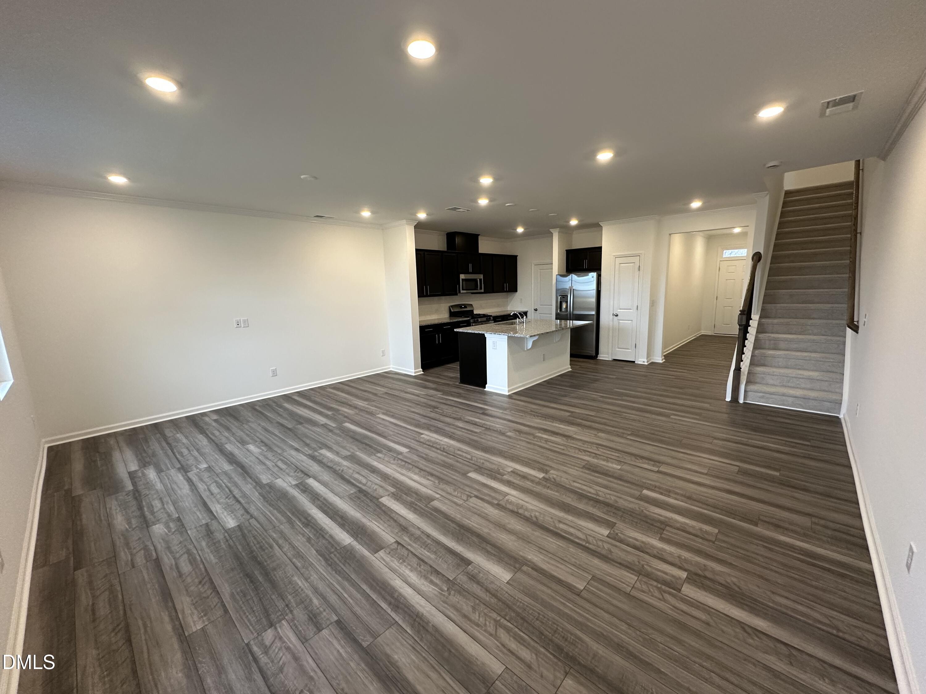 2917 Hickory Fld Drive Raleigh, NC 27616 - Photo 5 of 28 a open kitchen with kitchen island a sink dishwasher a refrigerator and a stove top oven with wooden floor