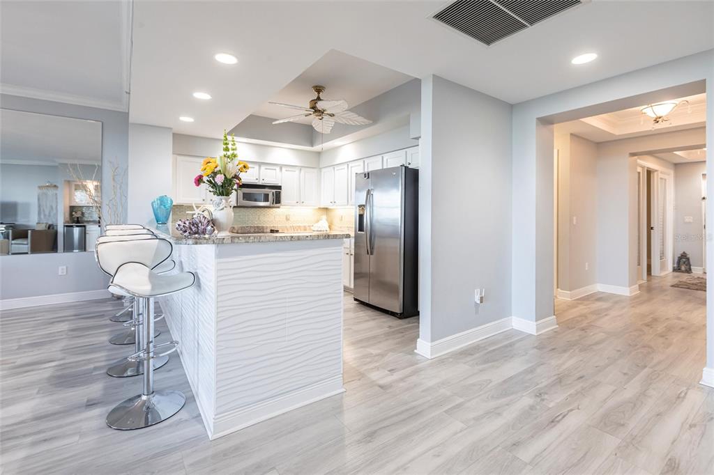 3329 Sunset Key Circle, Unit 107 Punta Gorda, FL 33955 - Photo 11 of 76 a kitchen with stainless steel appliances kitchen island granite countertop a refrigerator and microwave