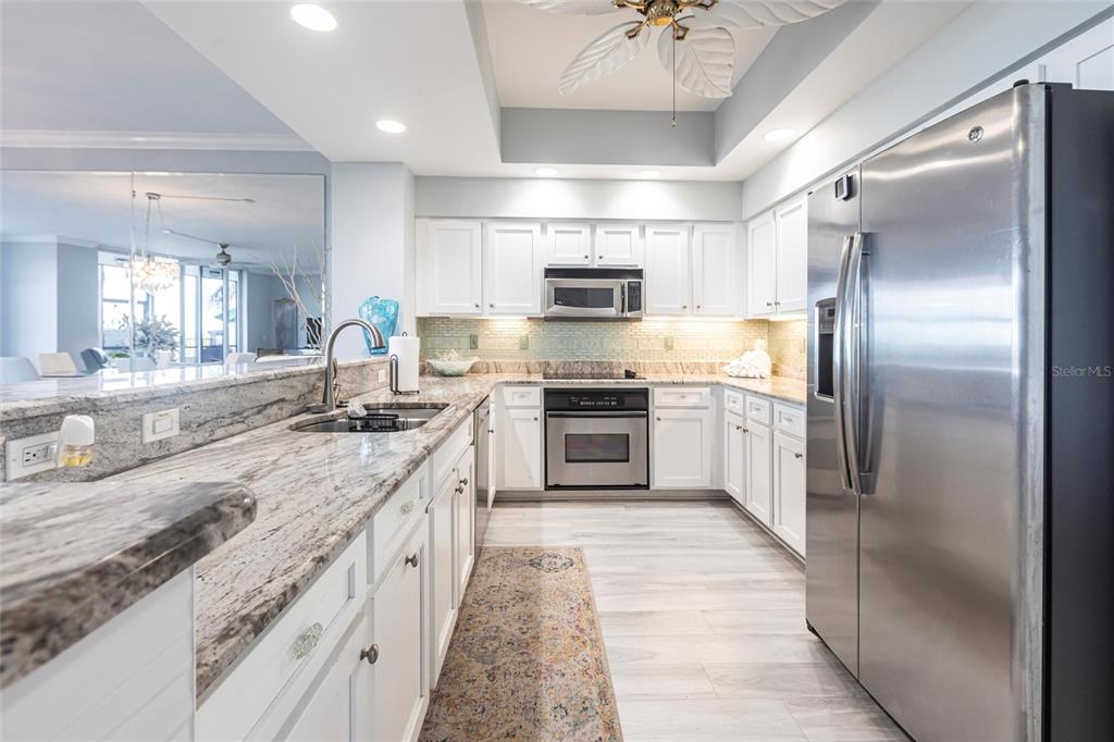 3329 Sunset Key Circle, Unit 107 Punta Gorda, FL 33955 - Photo 12 of 76 a large kitchen with stainless steel appliances granite countertop a sink a stove and a refrigerator