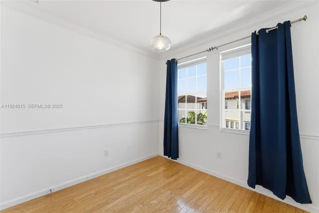a view of a livingroom with wooden floor and a window