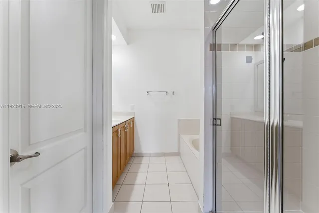 a bathroom with a granite countertop shower and a sink