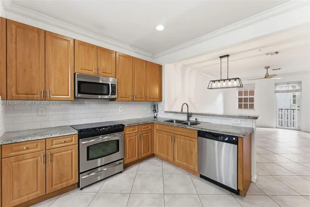 a kitchen with stainless steel appliances granite countertop a stove sink and microwave