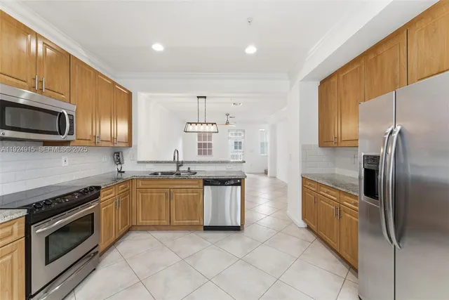 a kitchen with stainless steel appliances granite countertop a stove top oven a sink dishwasher a refrigerator and a microwave