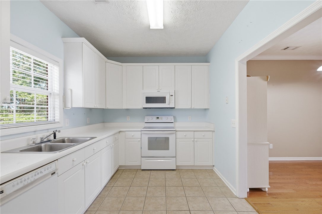 1213 North Dean Road Auburn, AL 36830 - Photo 9 of 18 Bright and airy, this kitchen features ample cabinetry and a serene atmosphere perfect for culinary endeavors.
