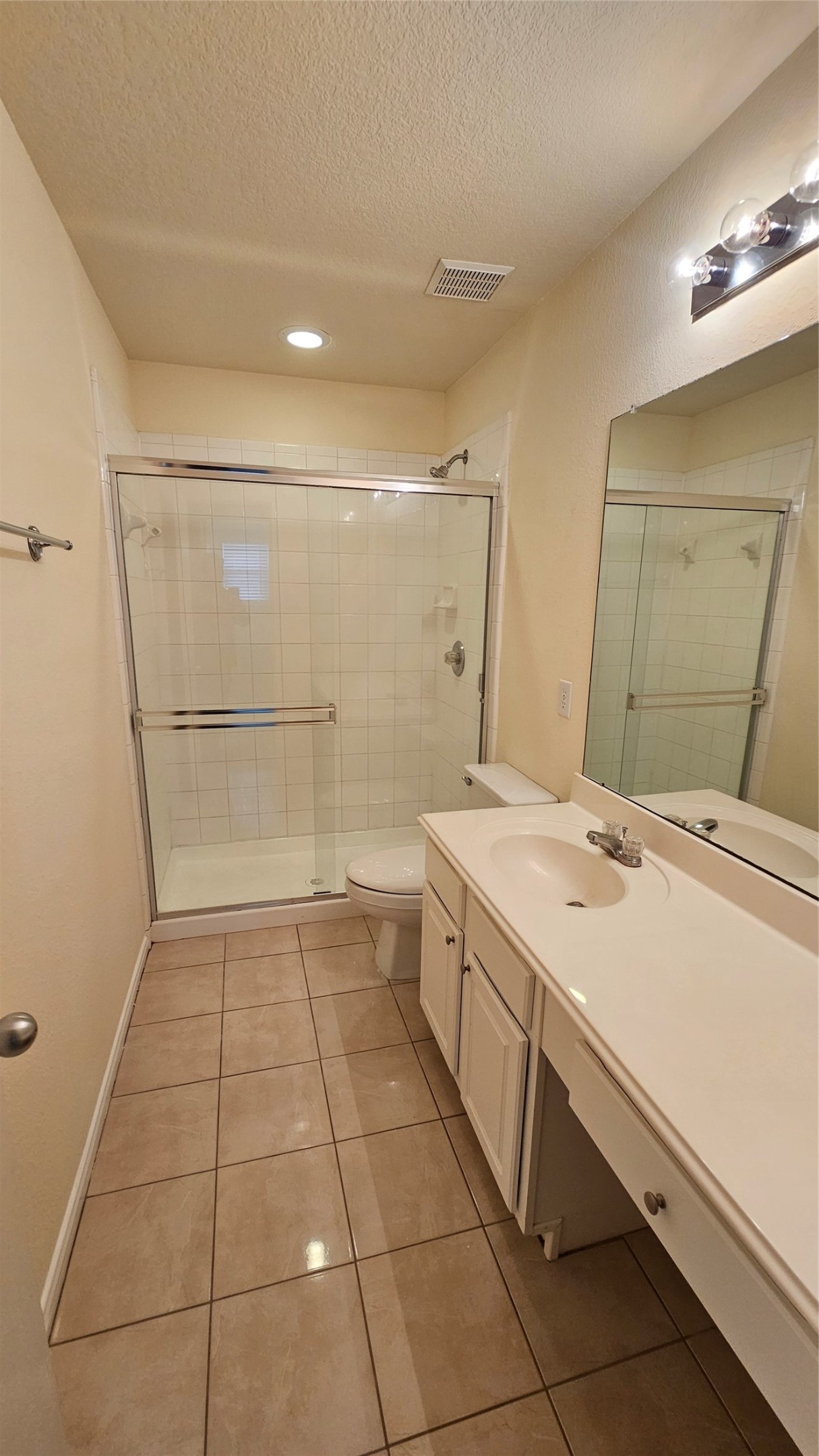 7918 Barnes Ridge Lane Houston, TX 77072 - Photo 17 of 34 This bathroom features a spacious shower with a glass door, a large vanity with a mirror, and neutral tile flooring, providing a clean and functional space.
