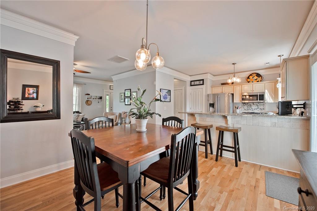 8147 Townley Road Huntersville, NC 28078 - Photo 14 of 35 a view of a dining room and livingroom with furniture wooden floor a rug a potted plant and a chandelier