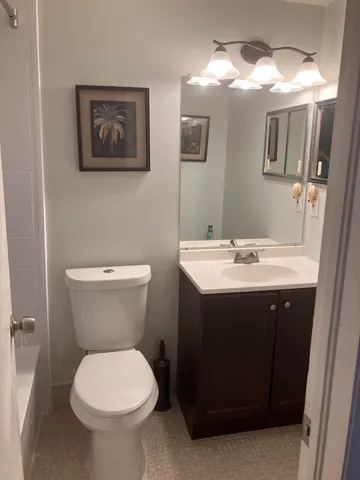 a bathroom with a toilet sink and mirror