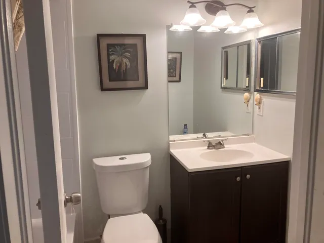 a bathroom with a toilet sink and mirror