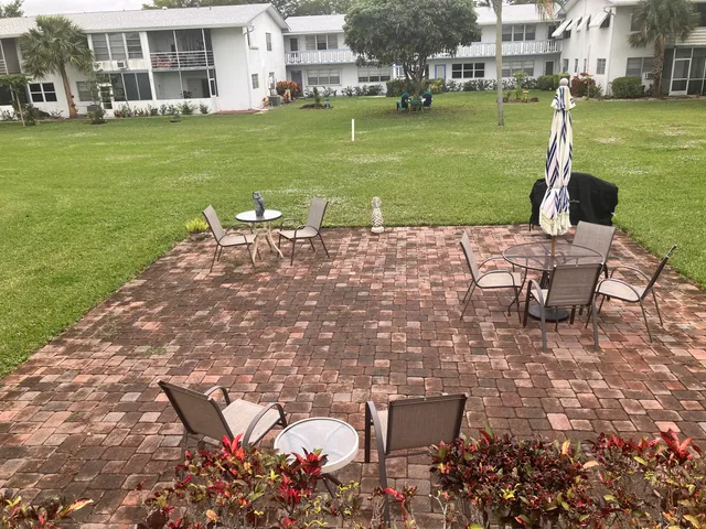 a view of a patio with table and chairs potted plants and large trees