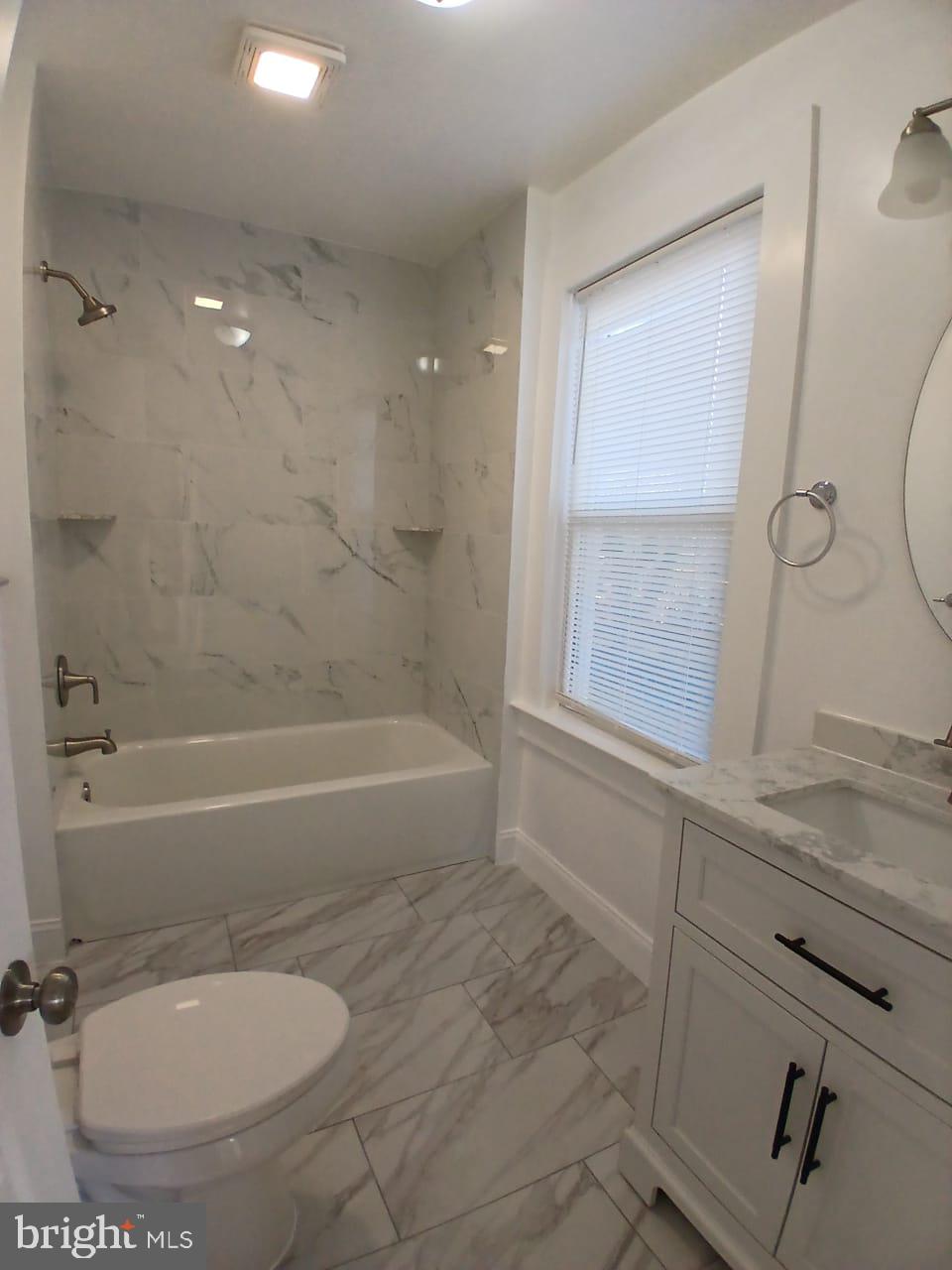 5505 Tramore Road Baltimore, MD 21214 - Photo 24 of 28 a bathroom with a granite countertop sink a toilet and bathtub