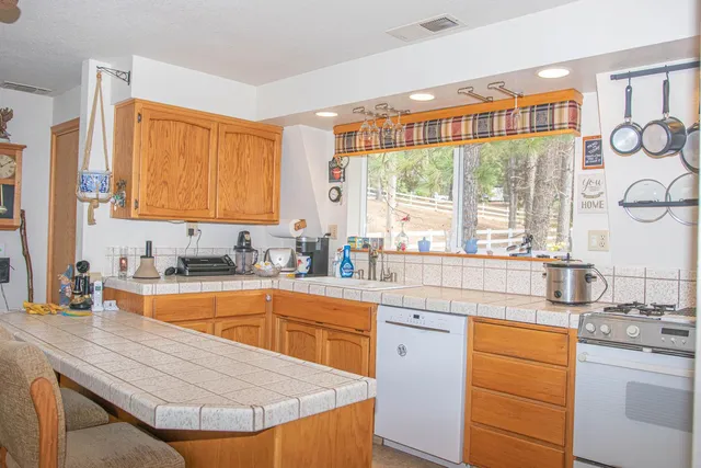 a kitchen with stainless steel appliances granite countertop a sink a stove and cabinets
