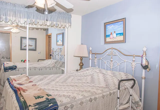 a bedroom with a bed a chandelier and dresser