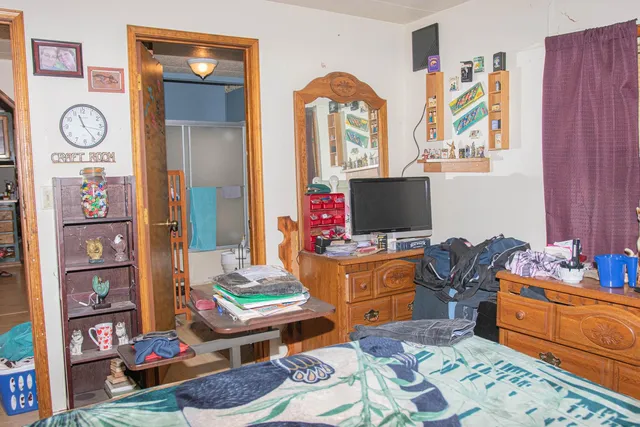 a bed sitting in a bedroom next to a window