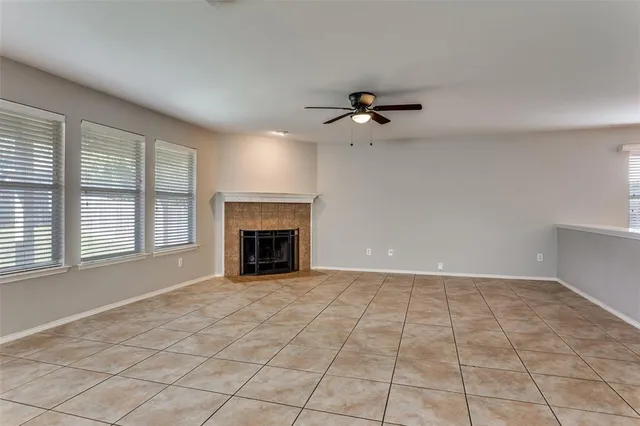 a view of an empty room with a fireplace and a window