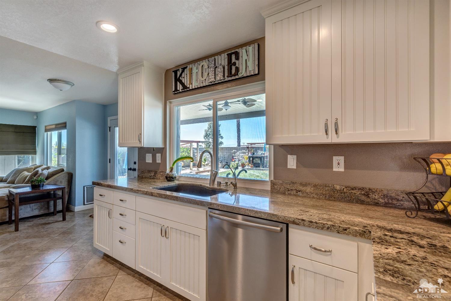 9043 Dancy Circle Riverside, CA 92508 - Photo 3 of 35 a kitchen with granite countertop white cabinets and white appliances