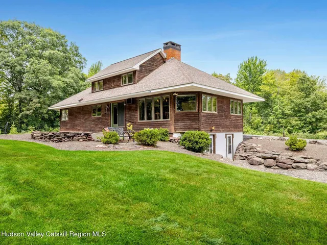 a front view of a house with patio and garden