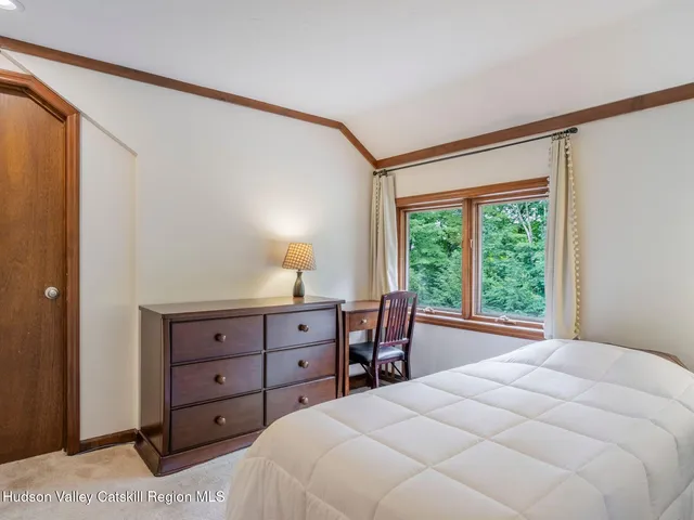 a bedroom with a bed and a flat tv screen on wall