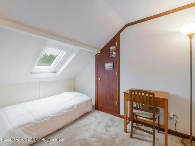 a bed room with a bed and a painting on the wall