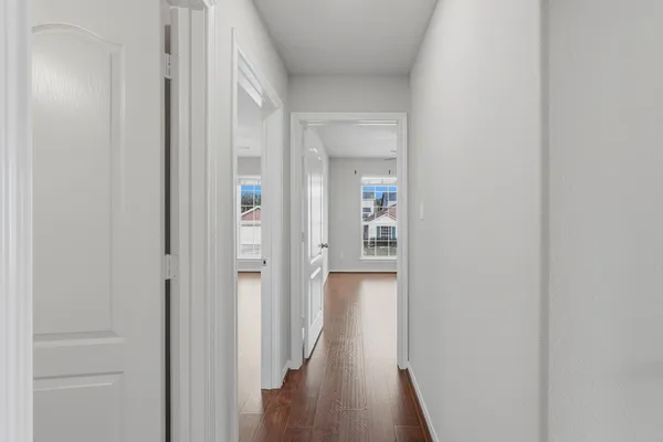 a view of a hallway with wooden floor