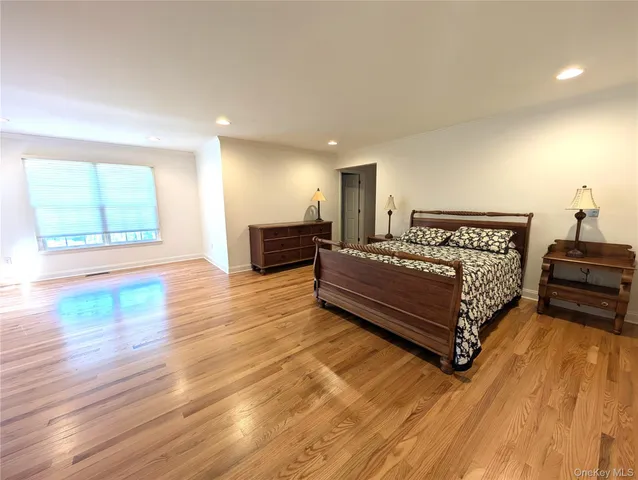 a bedroom with a bed wooden floor and window