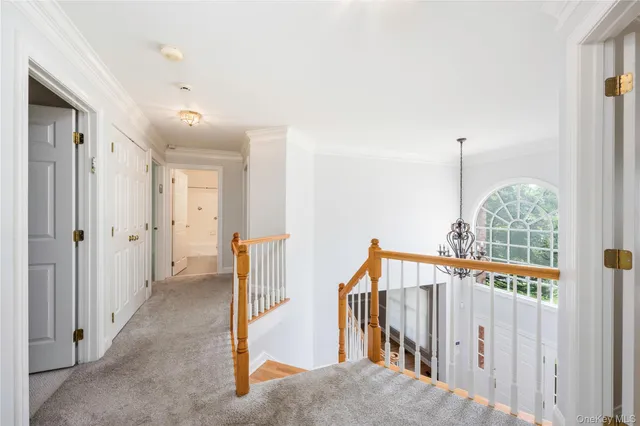 a view of a hallway with wooden floor and windows