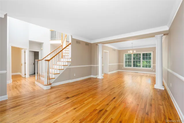 a view of empty room with wooden floor and windows