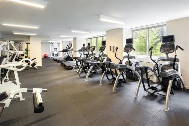 a living room with lots of white furniture and a window