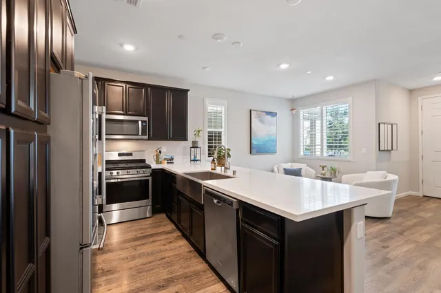 a large kitchen with kitchen island a sink stainless steel appliances and cabinets
