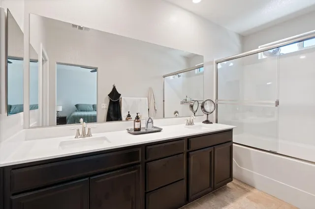 a bathroom with a double vanity sink and mirror