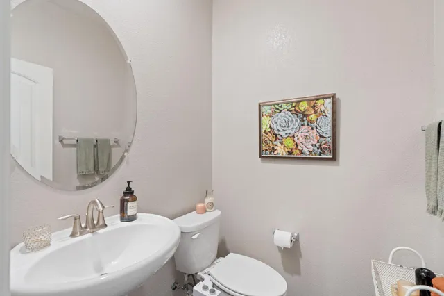 a bathroom with a toilet a sink and mirror