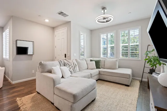 a living room with furniture a flat screen tv and a large window