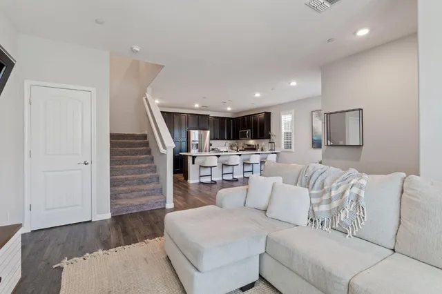 a living room with furniture and view of kitchen