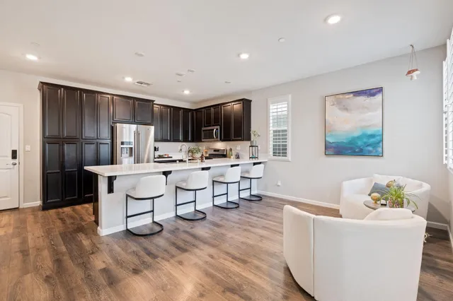 a living room with stainless steel appliances kitchen island granite countertop furniture and a kitchen view