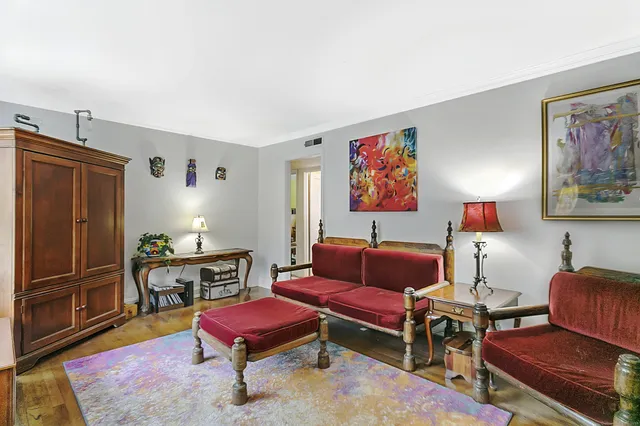 a living room with furniture a rug and a wall painting