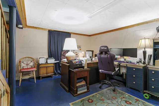 a view of a workspace with furniture and a window