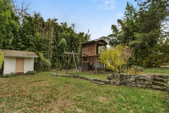 a view of a chair and table in backyard of the house