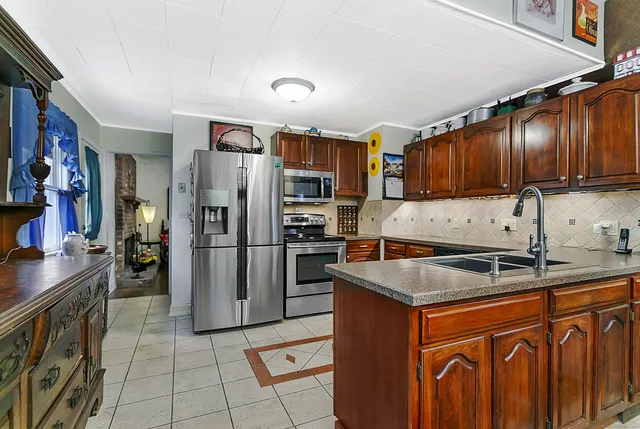 a kitchen with stainless steel appliances granite countertop a refrigerator a stove and a sink