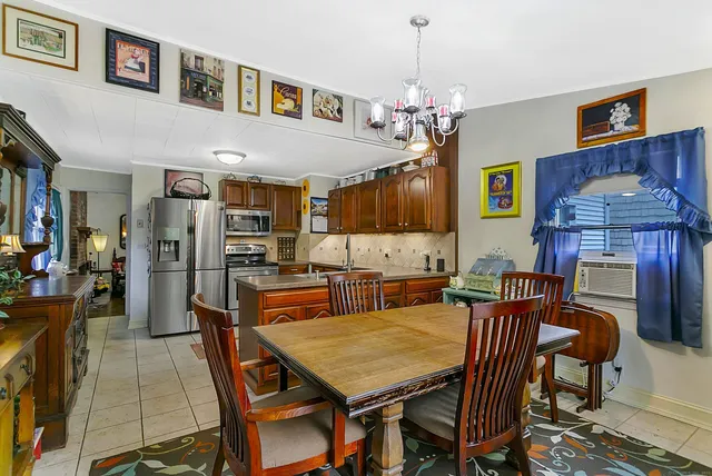 a view of a dining room with furniture a chandelier and wooden floor