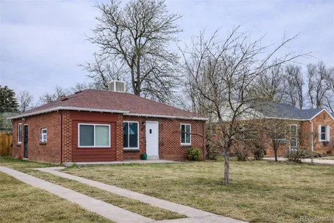 a view of a yard in front of a house with a large tree
