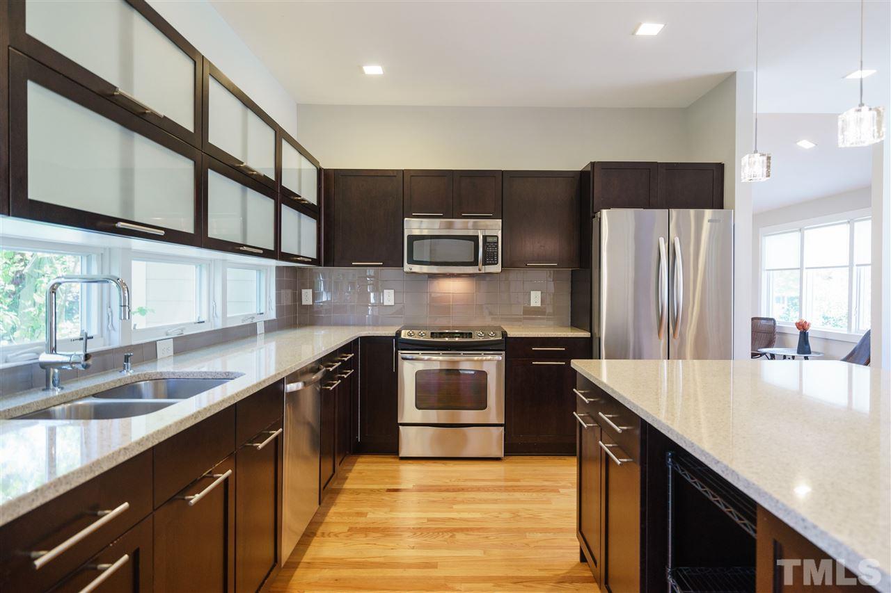 2514 Colton Place Raleigh, NC 27609 - Photo 12 of 25 a kitchen with stainless steel appliances granite countertop a sink a stove and a refrigerator