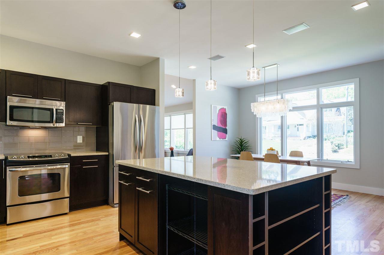2514 Colton Place Raleigh, NC 27609 - Photo 13 of 25 a kitchen with kitchen island granite countertop a sink appliances and cabinets