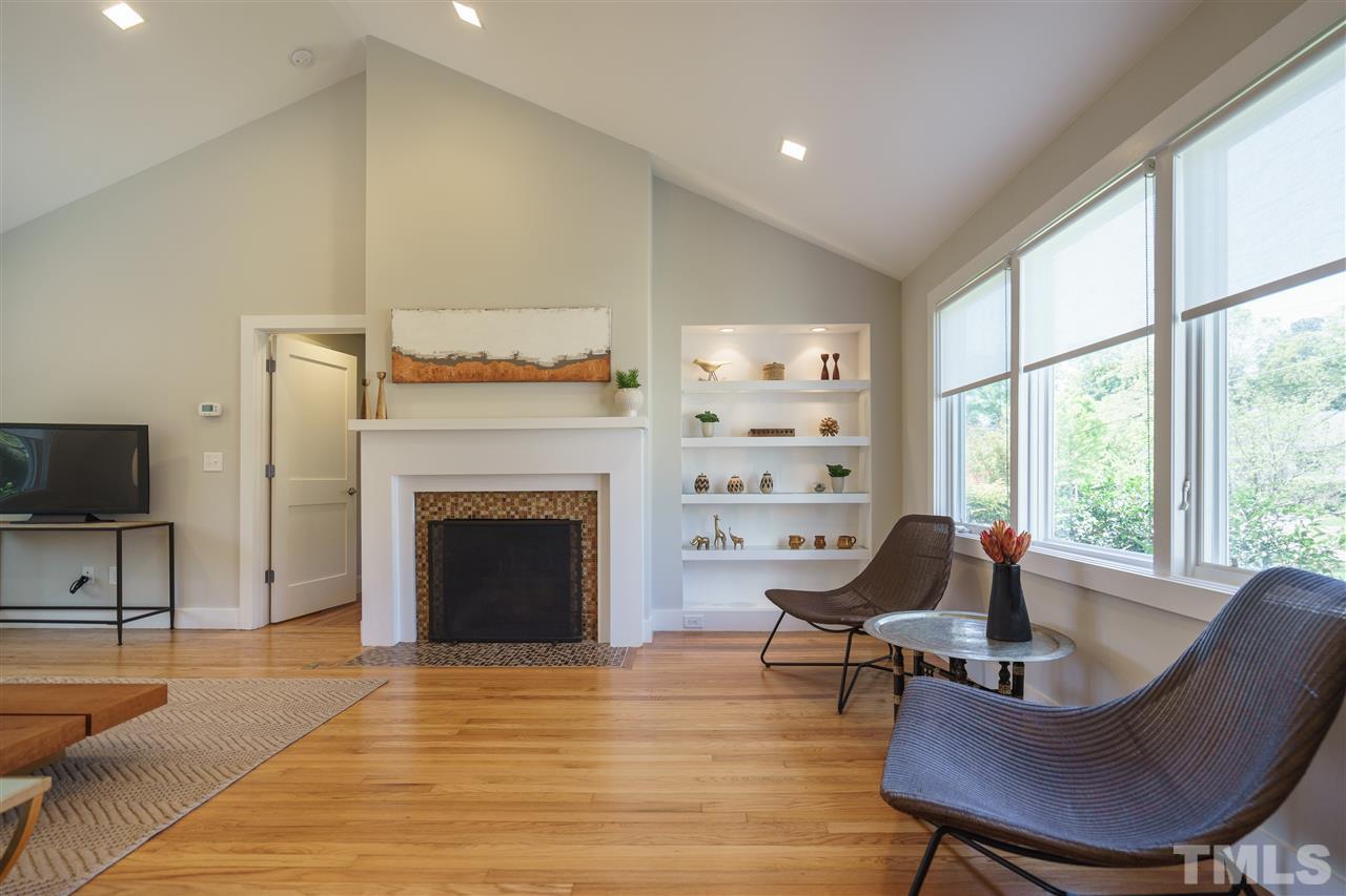2514 Colton Place Raleigh, NC 27609 - Photo 7 of 25 a living room with furniture a fireplace and a large window