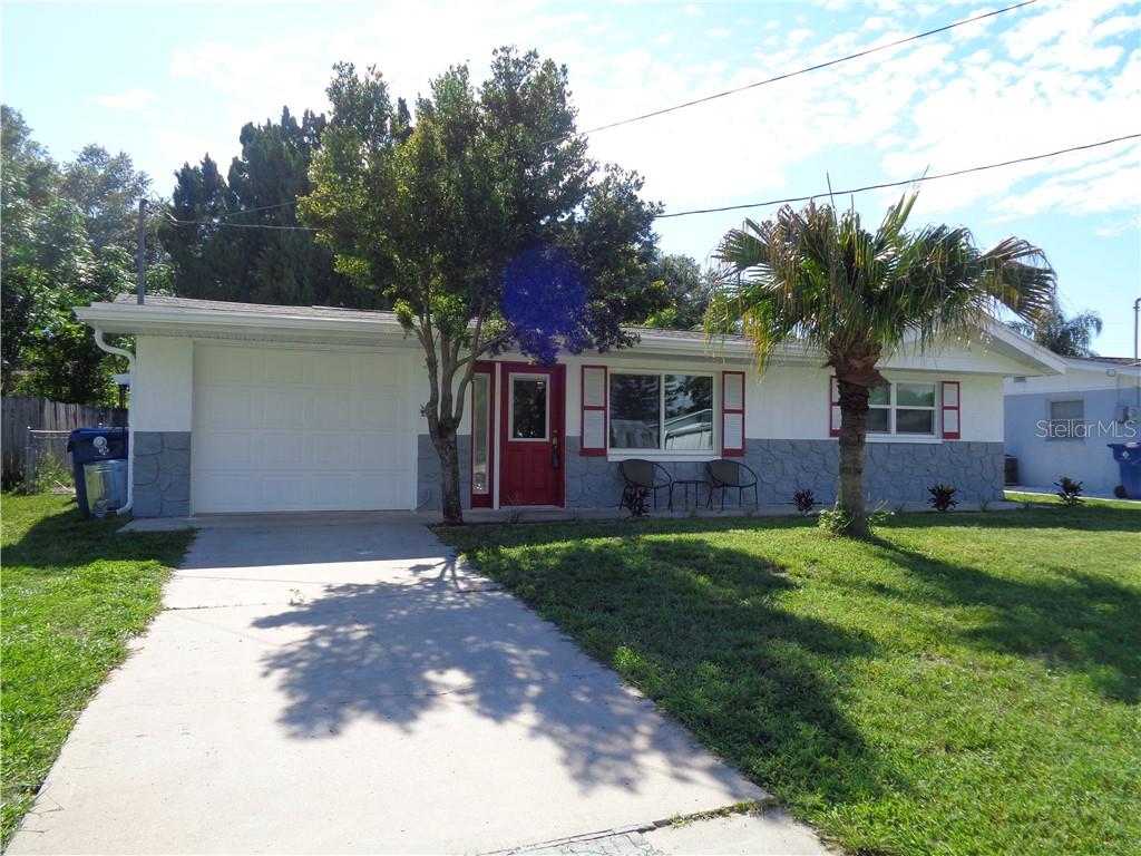 8917 Harvey Lane Port Richey, FL 34668 - Photo 1 of 1 a front view of a house with a yard and trees