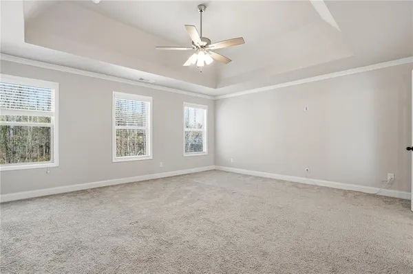 an empty room with windows and fan