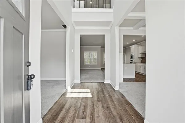a view of a hallway with wooden floor and a bathroom