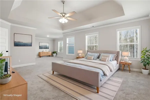 a spacious bedroom with a large bed a chandelier and windows