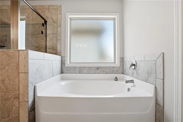 a white bath tub sitting next to a shower