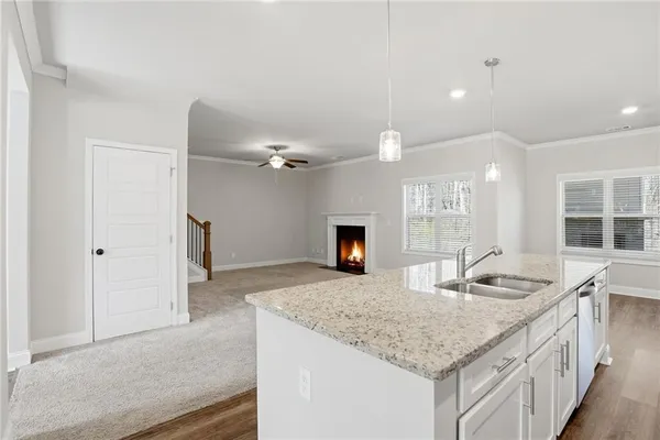 a hall with kitchen island a sink granite counter tops and a fireplace